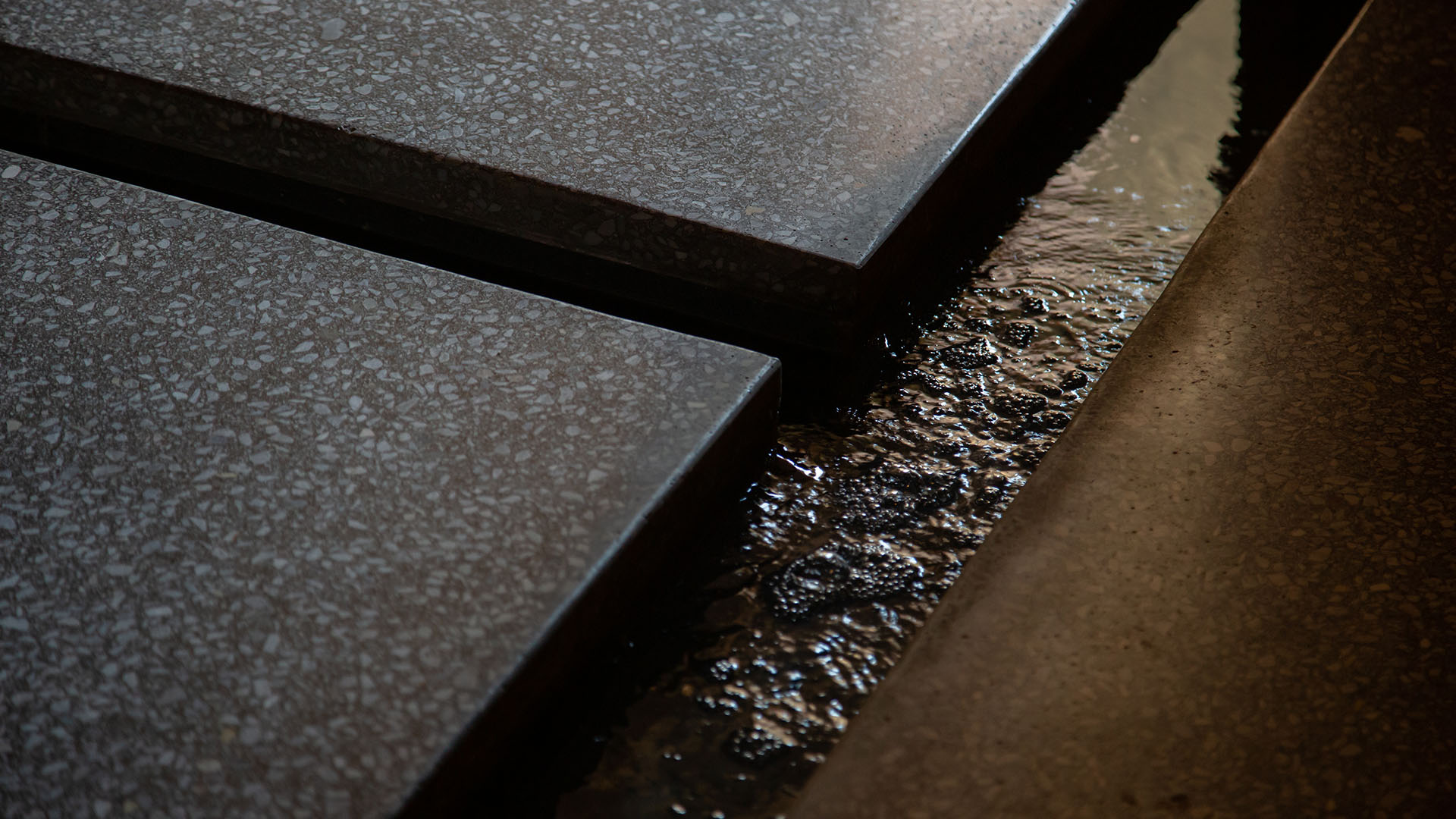 Minimal architectural detail with natural stone textures, light and shadow highlighting Casa Collective brand identity